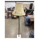 Vintage floor lamp features a slender metal pole