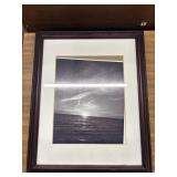 Framed artwork features a black and white ocean