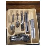 Beige plastic kitchen drawer organizer filled