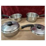 Bundle of saucepans, steamer strainer, and lids.