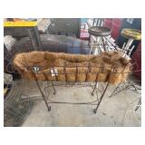 Rustic twisted-metal trough planter stand.