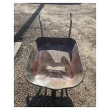 Old, weathered steel garden wheelbarrow.