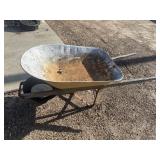 Weathered, single-wheel garden wheelbarrow.