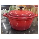 Vibrant red enameled cast iron Dutch oven with a