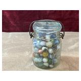 Vintage wire-bail canning jar full of marbles.