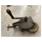 Vintage cast-iron hand-crank bench grinder.