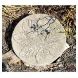 A round gray concrete garden stepping stone