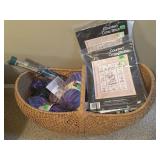 Basket full of cross stitch and knitting items.