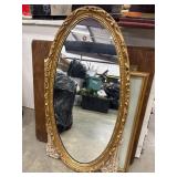 Vintage ornate gold-framed oval mirror.