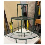 Green metal three-tier corner plant stand.