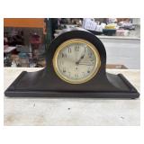 Antique wooden mantel clock with a round,