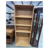 Tall, light oak wood-grain laminate bookcase