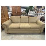 traditional tan upholstered sofa featuring