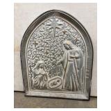 Embossed metal wall plaque featuring a