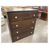Dark-stained wood 4-drawer chest of drawers.