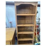 Tall, open-shelf wooden bookcase with an arched
