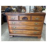 Wooden Chippendale-style chest of drawers.