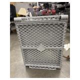 Folded plastic baby gate or play yard.