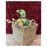 Woven basket and faux floral arrangement .