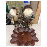 Two rustic Santa Claus figurines standing behind