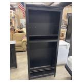Tall, matte black wooden bookcase. Shelves need