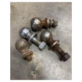 Four used, assorted trailer hitch balls.