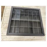 Black wall-mounted shadow box display case.