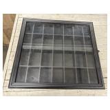 Black shadow box wall-mounted display case.