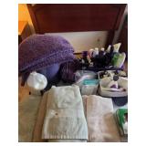 Garbage can, purple bath rugs, towels, bathroom