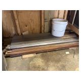 Lumber and pipe under work bench, approximately