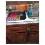 Kitchen sink, cleaning supplies under cupboard and in sink