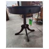 vintage Regency-style drum table with lion head pulls and reeded legs.