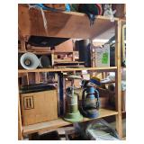 Contents of shelf. Lanterns, window fan, tins