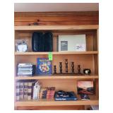 Contents of three shelves DVDs books and miscellaneous items