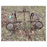Antique horse-drawn agricultural implement, likely a cultivator or a planter.