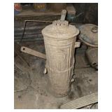 antique stationary engine, commonly known as a "hit-and-miss" engine from the early 20th century. antique cast iron housing for a portable, freestanding vertical water heater,