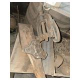 vintage pipe vise, cast iron cattle bowl, and old chains and casters in vintage corned beef box