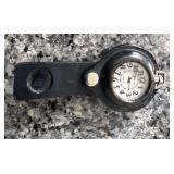 Relic brand pocket watch housed in a black leather carrying case, similar to vintage trench watch holders designed to be worn on a belt or wrist.