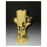 Warranted ceramic bud vase features a yellow tree stump design with 22K gold accents and a small squirrel figure.