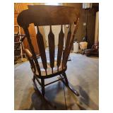 vintage wooden rocking chair featuring a gold stenciled floral design on the top crest rail
