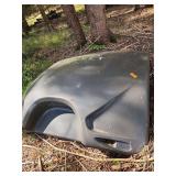 detached, dark-colored fiberglass front cap from a CrossRoads Sunset Trail travel trailer