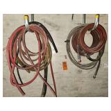 coiled red-jacketed high-pressure hose, likely a pressure washer or hydraulic hose and other tubing
