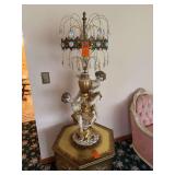 The selected region appears to show a vintage Azzolin Bros. Classical Style Cherub Crystal Lamp featuring porcelain cherub figures and cascading crystal prisms. [1] (https://www.invaluable.com/auction