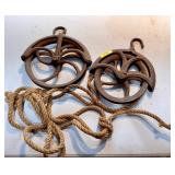 2 antique well pulleys with rope