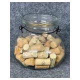 Chipped rim glass candle holder filled with corks