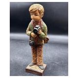 Vintage textured boy figurine holding a camera