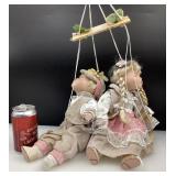 2 poupées de porcelaine, sur balançoire