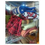 Stack of linens new and used blankets throws