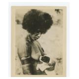 African Woman Breastfeeding a Dog Photo