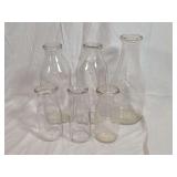 Group of Six Clear Glass Milk Bottles in Various Capacities